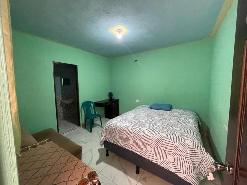 um quarto com uma cama, uma mesa e uma cadeira em Casa Julia Xela em Quetzaltenango