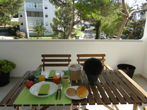 une table avec des assiettes de nourriture sur un balcon dans l'établissement CCC - Cascais Calm & Comfort, à Cascais