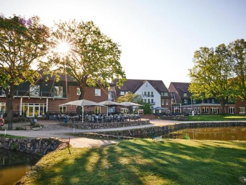 grupa budynków z drzewami i stawem w obiekcie Steigenberger Hotel Treudelberg Hamburg w mieście Hamburg