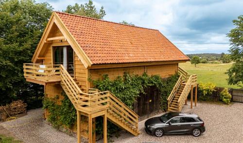 une petite maison avec une voiture garée devant elle dans l'établissement Góra Jabłek Mazury Mikolajki, à Lipowo