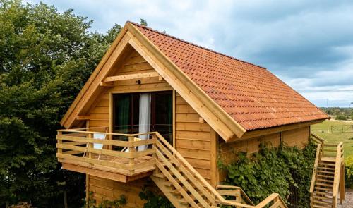 une cabane en rondins avec une terrasse et un toit dans l'établissement Góra Jabłek Mazury Mikolajki, à Lipowo