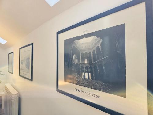 a framed picture of a building on a wall at Leopold Chillout Hostel in Sarajevo