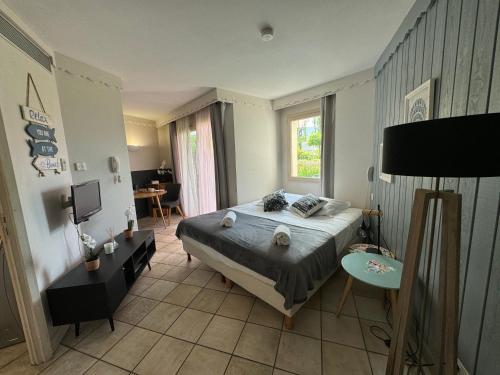 Appartement Le Beach du Lac d'Annecy avec les pieds dans l eau, plage et ponton privé في دْوا: غرفة نوم فيها سرير وطاولة فيها