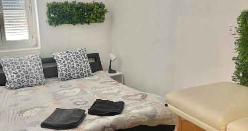 - une chambre avec un lit et 2 serviettes noires dans l'établissement Appartement cosy LYON, à Villeurbanne