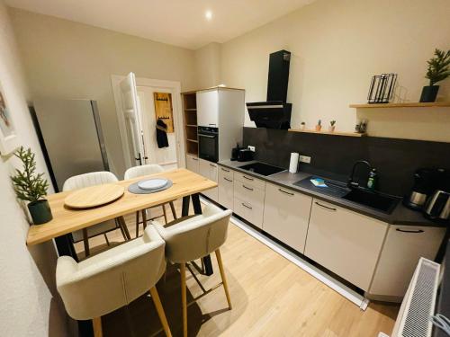 a kitchen with a table and some chairs in it at COZY, neue 3 Zimmer Ferienwohnung Goslar Altstadt in Goslar