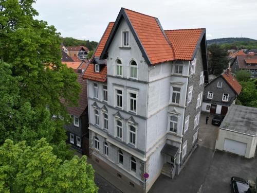 a tall white building with an orange roof at COZY, neue 3 Zimmer Ferienwohnung Goslar Altstadt in Goslar