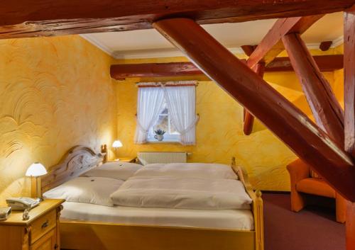 a bedroom with a bed in a room with yellow walls at Hotel Gut Voigtlaender in Blankenburg