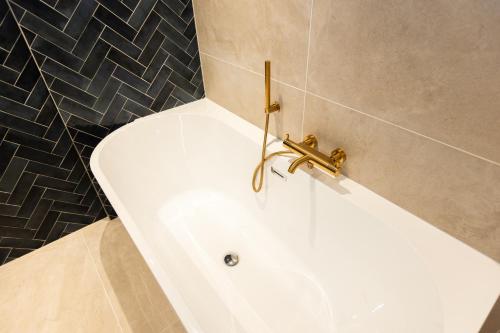 La salle de bains est pourvue d'une baignoire avec un robinet. dans l'établissement 6 persons Luxury Appartement in Citycentre Breda, à Breda