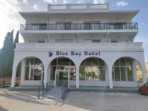 伊拉克里萨Blue Bay Hotel的一座白色的建筑,带有蓝色的海湾酒店