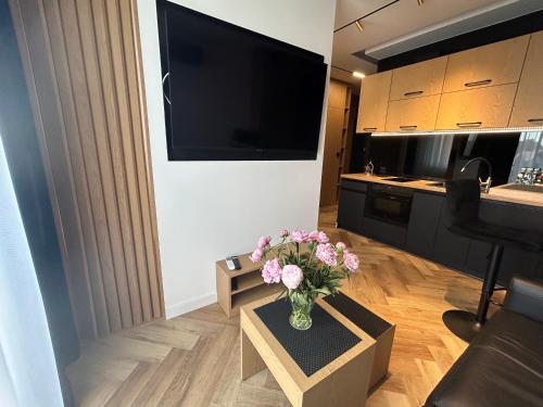 ein Wohnzimmer mit einer Blumenvase auf dem Tisch in der Unterkunft Business Apartment Płock in Płock