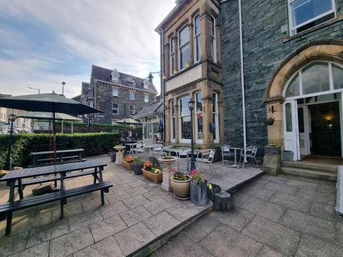 un patio avec une table et des bancs et un bâtiment dans l'établissement Keswick Park Hotel, à Keswick