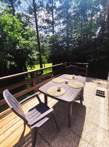 een picknicktafel en twee stoelen op een terras bij Au bois charmant in Waulsort