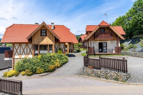 a house with a fence in front of it at Domki Całoroczne Osada Zbójecka Jandura in Kluszkowce