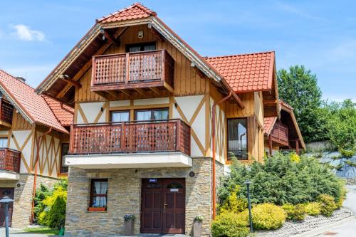 a house with a balcony on top of it at Domki Całoroczne Osada Zbójecka Jandura in Kluszkowce