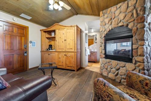 een woonkamer met een stenen open haard en een televisie bij Adobe Village Studio Suite- Sundance condo in Sedona