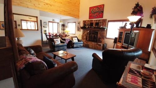 sala de estar con sofás y chimenea en Birds and Bears Retreat - On The River - Pet Friendly - WiFi - Satellite - Washer - Dryer - Large Deck - Grill - Fenced In Yard, en Red River