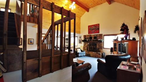 una sala de estar con una escalera en una casa en Birds and Bears Retreat - On The River - Pet Friendly - WiFi - Satellite - Washer - Dryer - Large Deck - Grill - Fenced In Yard, en Red River