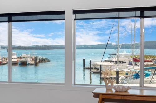 a view of a marina from a room with windows at Harbour Marina - Absolute waterfront apartment in Batemans Bay