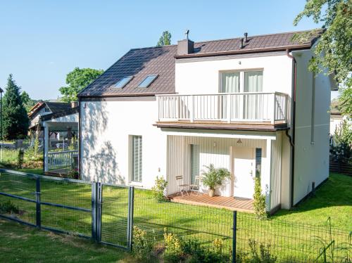 ein weißes Haus mit einem Balkon und einem Hof in der Unterkunft Leo House in Gdynia