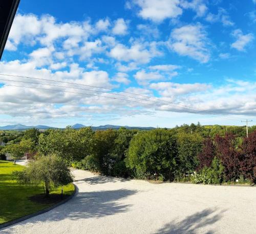 Elle offre une vue sur une allée avec des arbres et un ciel bleu. dans l'établissement Ashville Guesthouse, à Westport