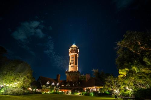 ein großes Gebäude mit einem Uhrturm in der Nacht in der Unterkunft Hotel L'Auberge in Punta del Este