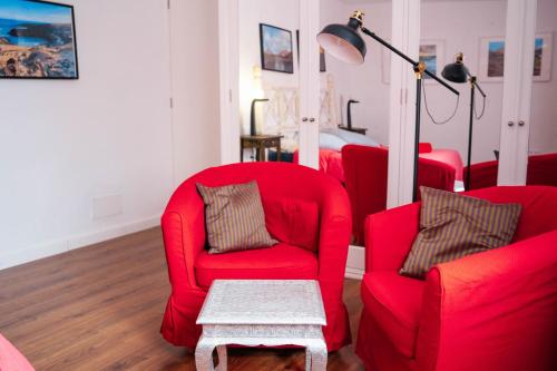 a living room with red chairs and a table at hotel rural GA7COLORES only adult in Montaña Blanca