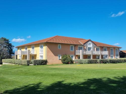 ein großes Apartmenthaus mit einem grünen Hof in der Unterkunft Best Western Golf d'Albon in Albon