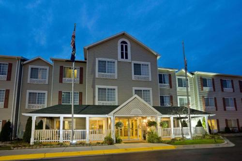 グランドラピッズにあるCountry Inn & Suites by Radisson, Grand Rapids Airport, MIの旗の目の前の大きな建物