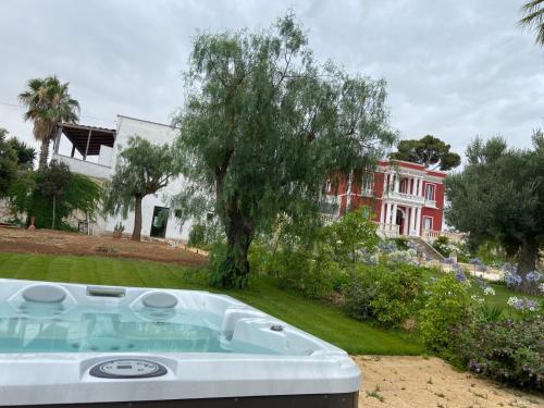 una bañera de hidromasaje en un patio con un árbol en Six Star Boutique Hotel, en Monopoli