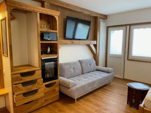 a living room with a couch and a tv at Hotel Blumenbach in Berlin