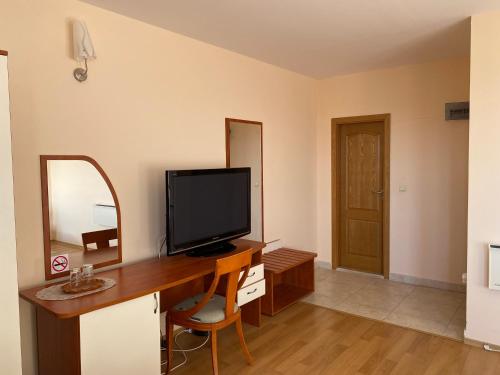 a room with a desk with a television and a mirror at Guest House Golden Flake 4km from Bolata beach in Bŭlgarevo