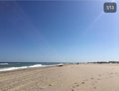 a beach with footprints in the sand and the ocean at Гостевой дом золотые пески in Zatoka