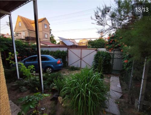 a car parked in a yard with a fence at Гостевой дом золотые пески in Zatoka