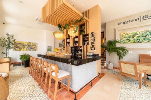 um restaurante com um bar com cadeiras e mesas em Empyrean Art Deco em Santo Domingo