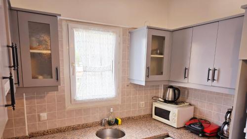 een keuken met witte kasten en een magnetron bij 3 Bedrooms Apartment in Ölüdeniz, Ovacik in Oludeniz