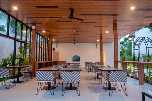 a restaurant with wooden ceilings and tables and chairs at Ratan Uluwatu Hotel and Villas in Uluwatu