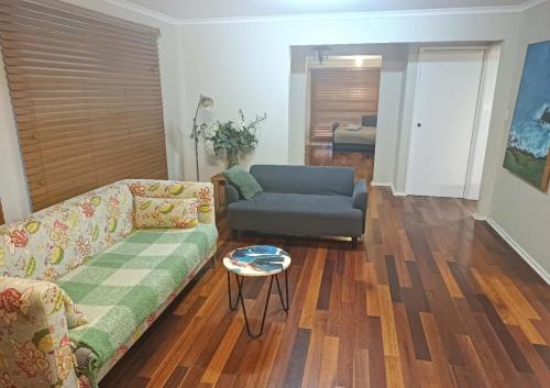 Spacious and cozy home next to Glen Waverley في Wantirna South: غرفة معيشة مع أريكة وكرسي