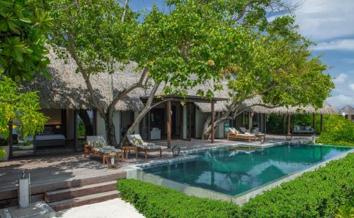 una piscina frente a una casa con árboles en Baros Maldives, en Male