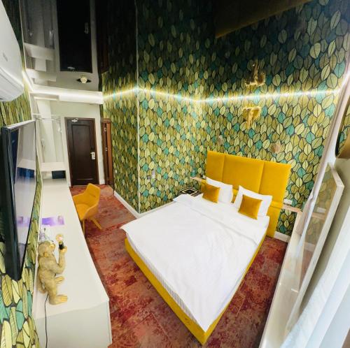 a bedroom with a bed with a yellow headboard at Villa & Restaurant Levoslav House in Sibiu