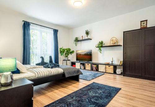 a living room with a couch and a large window at Riverside Apartment No1 in Esztergom