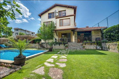 een huis met een zwembad in een tuin bij Villa Komitata-Pool and Jacuzzi in Balchik