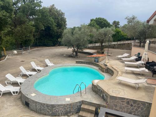 una grande piscina con sedie a sdraio intorno di AIR B&B PLEASANT MOMENTS a Bolsena