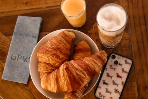 a plate of croissants and a glass of orange juice at Résidence de l'Arsenal Royal - Meublés de Tourisme in Rochefort