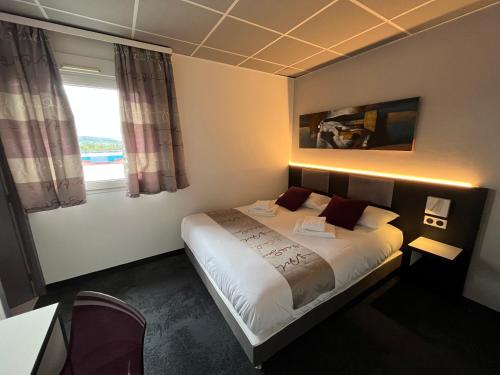 ein Hotelzimmer mit einem Bett und einem Fenster in der Unterkunft BRIT HOTEL LE VESOUL in Vesoul