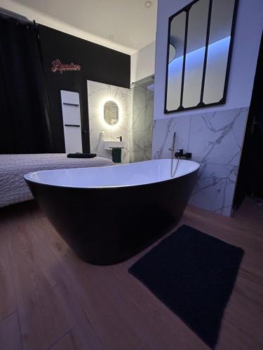 eine große Badewanne in einem Zimmer mit einem Bett in der Unterkunft L evazion appartement Grenoble in Grenoble