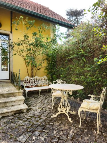 een patio met een tafel en stoelen voor een huis bij Sintra Chalet in Sintra