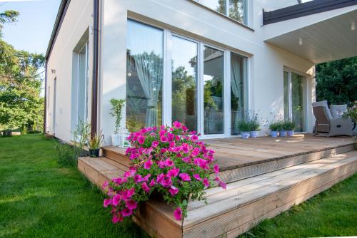 ein Haus mit einer hölzernen Veranda mit Blumen darauf in der Unterkunft Leo House in Gdynia