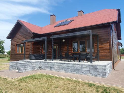 a log cabin with a red roof and black chairs at Apartament nr 1 Chorzelów in Mielec