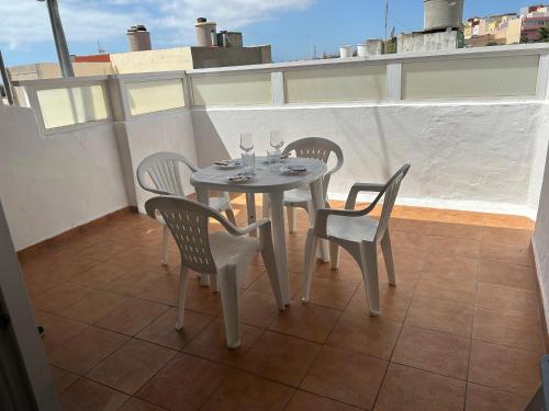 una mesa con sillas y copas de vino en el balcón en Garza Attic House, en Ojos de Garza