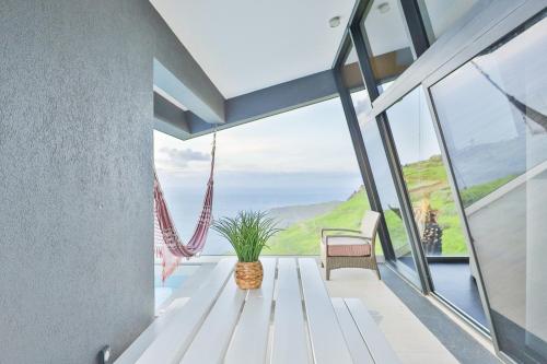 een huis met uitzicht op de oceaan bij Villa Leonor Cliffside Retreat in Calheta